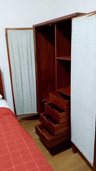 Armario de madera con puertas de madera y tela.