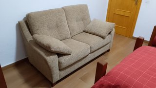 Sofá de tela beige.
