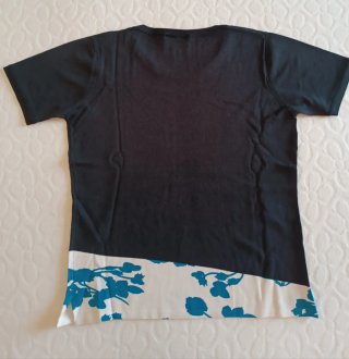 T-shirt nera con stampa floreale blu.