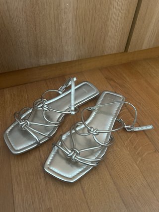 Sandalias doradas planas con nudos