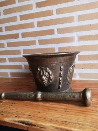Mortero de bronce antiguo con escudo y figura