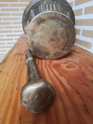 Mortero de bronce antiguo con escudo y figura