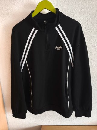 Sudadera negra con cremallera y detalles