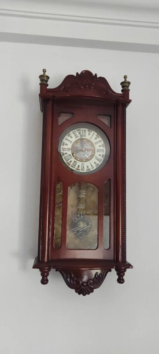 Reloj de pared clásico de madera, de cuerda.