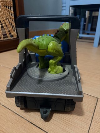 Camión azul con dinosaurio verde