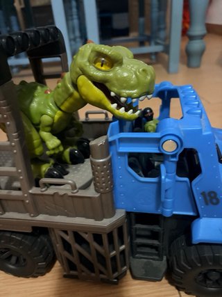Camión azul con dinosaurio verde