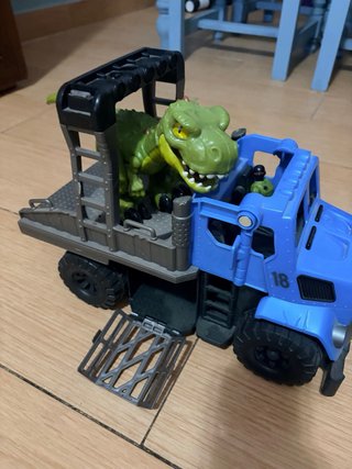 Camión azul con dinosaurio verde