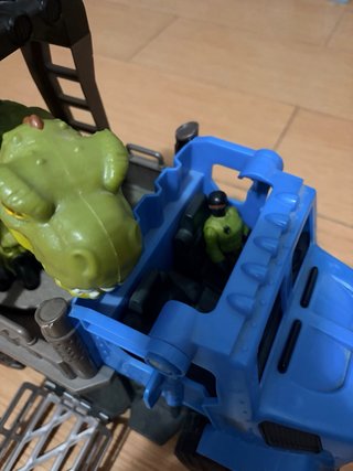 Camión azul con dinosaurio verde