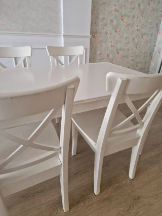 Mesa blanca con 4 sillas ikea y 1 taburete.