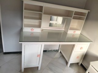 Escritorio blanco con estantería y cristal.