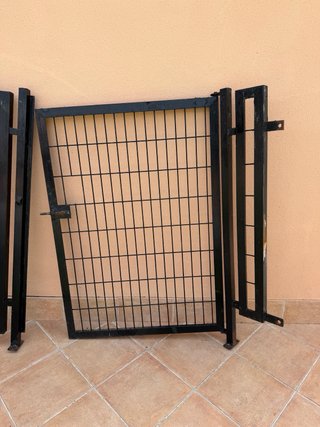 Valla metálica de jardín con puerta.