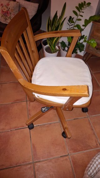 Silla de madera con ruedas y cojín beige