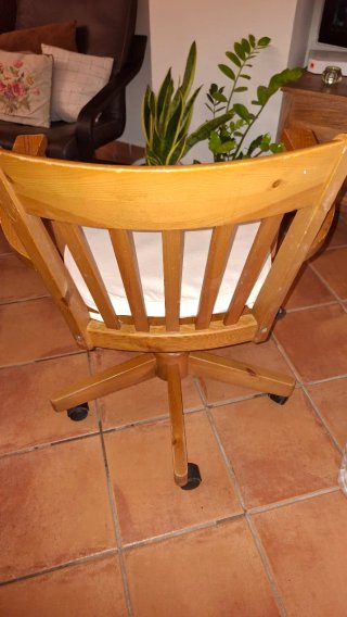 Silla de madera con ruedas y cojín beige