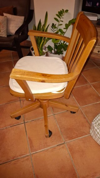 Silla de madera con ruedas y cojín beige