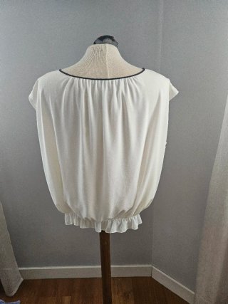 Blusa blanca vaporosa con detalle floral