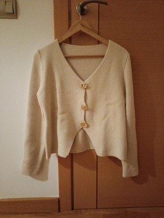 Chaqueta beige con botones dorados. No tiene marca