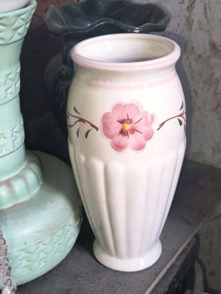 Jarrón de cerámica blanco con flor rosa