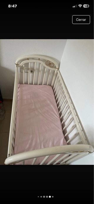 Cuna de bebé blanca con detalles dorados