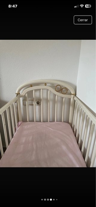 Cuna de bebé blanca con detalles dorados