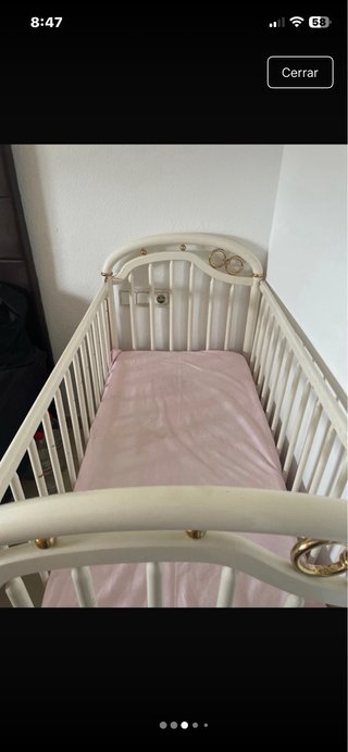 Cuna de bebé blanca con detalles dorados