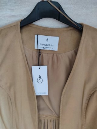 Chaleco Stradivarius ante flecos beige.