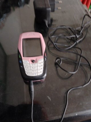 Teléfono móvil rosa con cargador