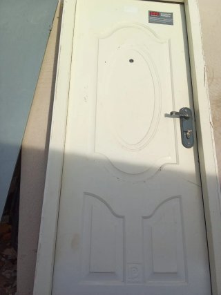 Puerta blanca con cerradura y mirilla