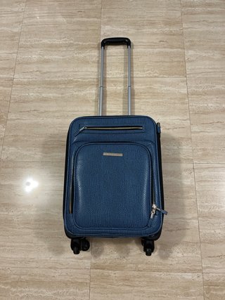 Maleta de viaje azul con detalles plateados