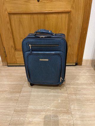 Maleta de viaje azul con detalles plateados