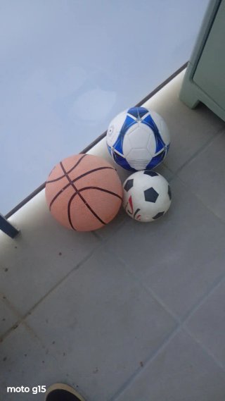 Palloni da basket e due palloni da calcio