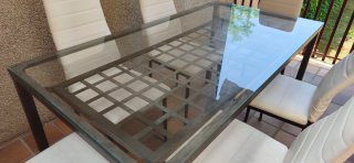 Mesa cristal y metal con 6 sillas blancas
