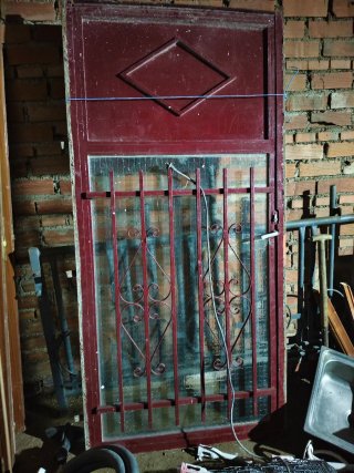 Puerta de metal con cristal y rejas