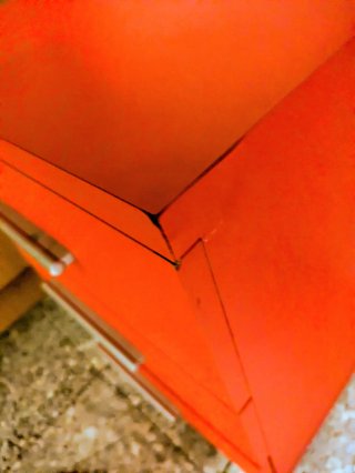 Cómoda roja con tiradores plateados