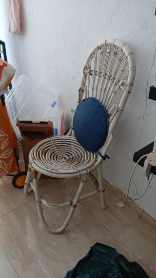 Silla de mimbre blanca con cojín azul