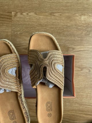 Sandalias doradas con etiqueta