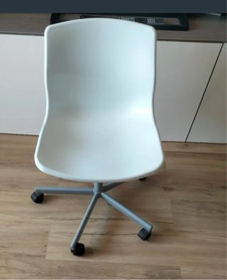 Mesa blanca con cajón azul y silla con ruedas