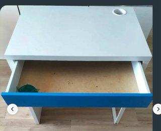 Mesa blanca con cajón azul y silla con ruedas