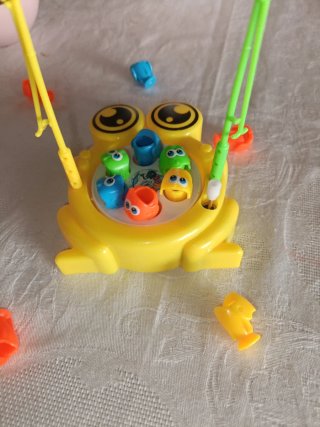 Rana,dos varitas de pescar y doce piececitos.
