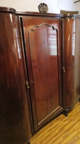 Cama de madera oscura con cómoda y armario