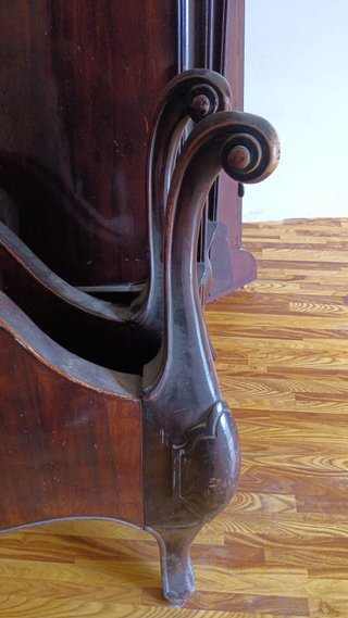 Cama de madera oscura con cómoda y armario