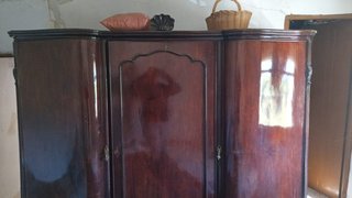 Cama de madera oscura con cómoda y armario