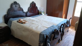 Cama de madera oscura con cómoda y armario