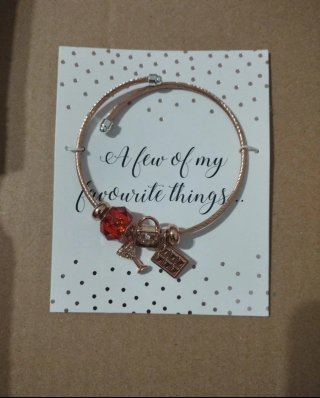 Pulsera Avon con charms dorados y rojos