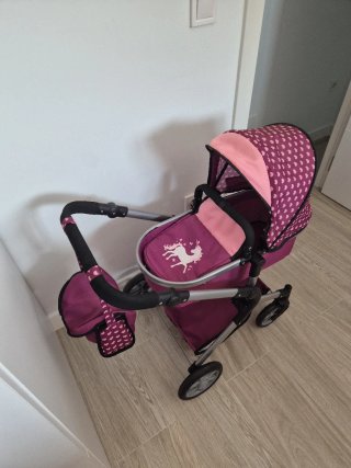 Carrito de muñecas rosa con bolso.