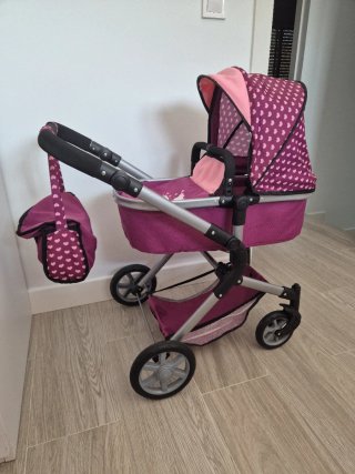 Carrito de muñecas rosa con bolso.