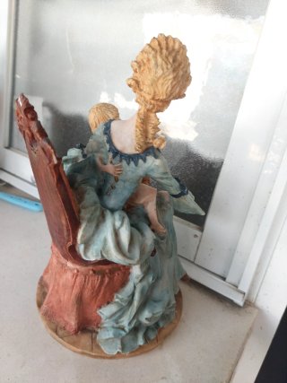 Figura mujer con niño en su regazo sentados .