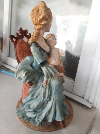 Figura mujer con niño en su regazo sentados .