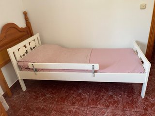 Cama infantil blanca con barrotes decorados