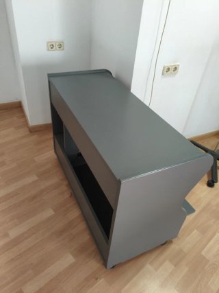 Escritorio gris con cajón y estantes