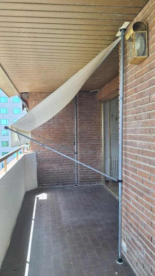 Toldo crema anclado suelo y techo.